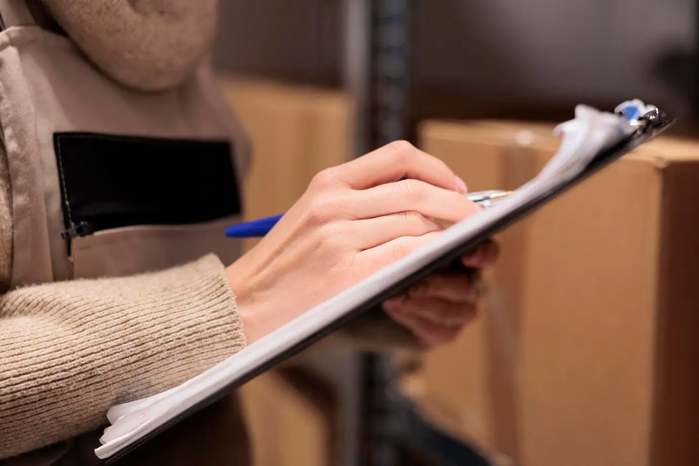 postal office storage worker holding clipboard warehouse marking inventory checklist warehouse employee hand writing with pen close up checking cardboard boxes storehouse 482257 66371
